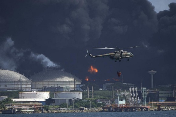 Helicópteros llevan agua hasta el lugar del incendio para evitar que el fuego se propague. Foto: AP.